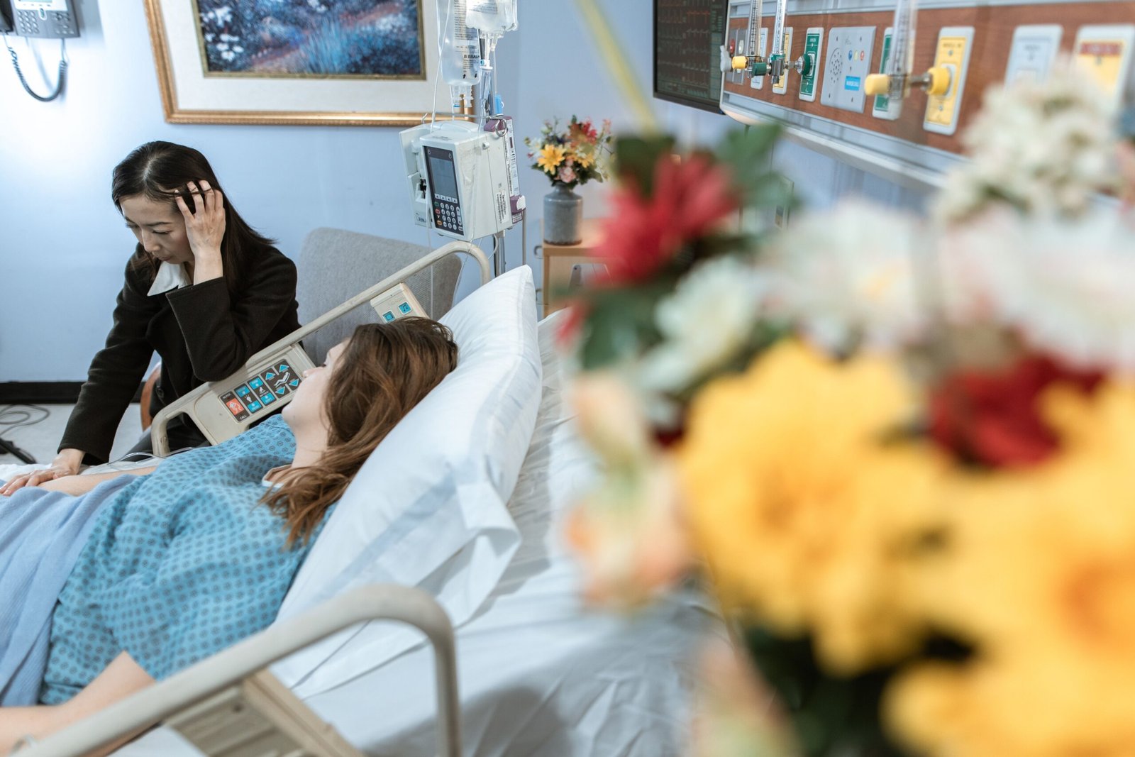Family member visiting an older patient in a hospital room