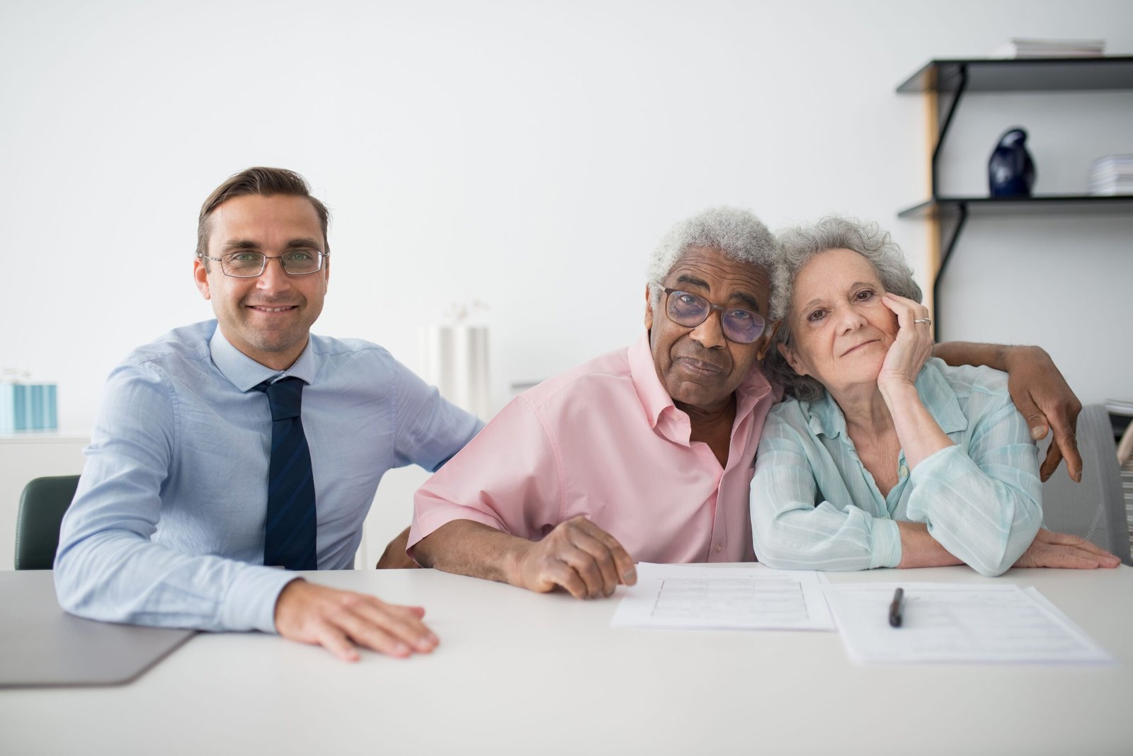 Older adults and a representative reviewing paperwork together