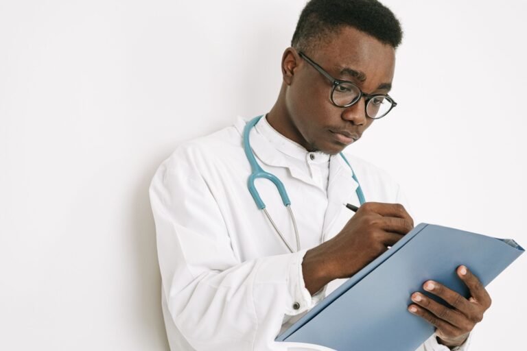 Clinician writing notes on a medical folder