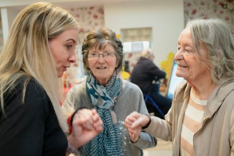 Three older women talking together during a group meeting