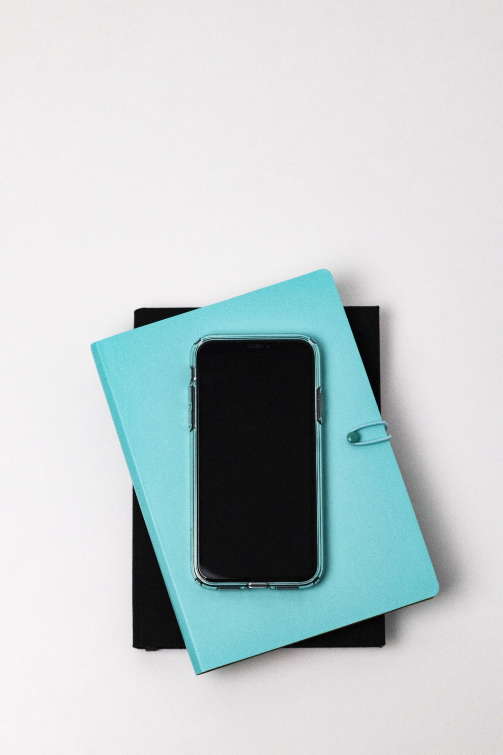 Smartphone resting on stacked notebooks for care communication planning