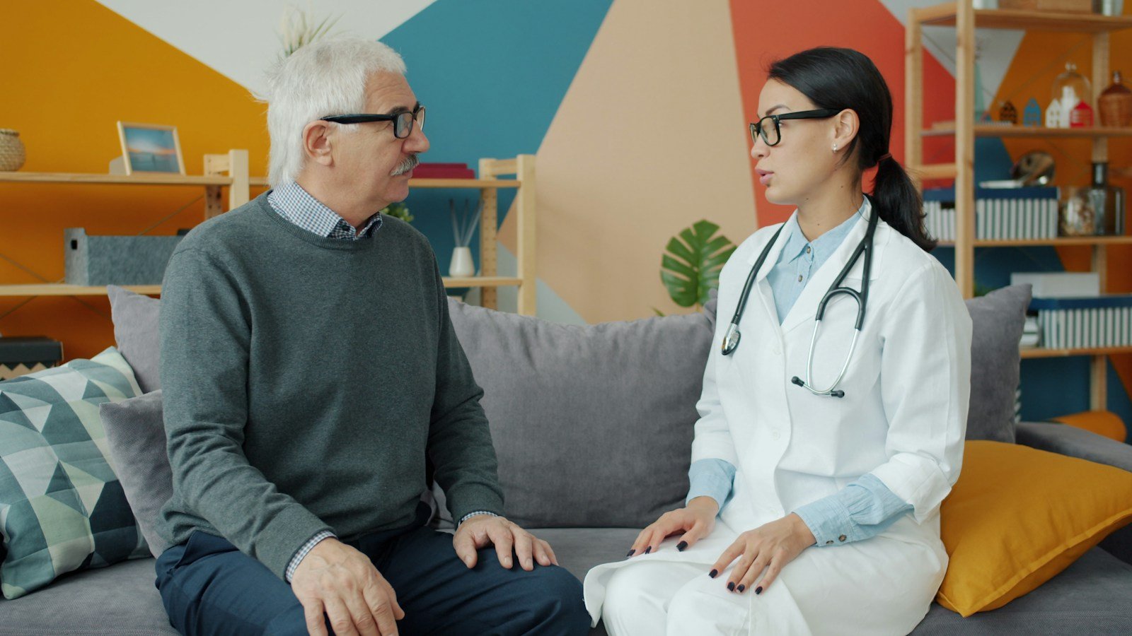 Healthcare professional speaking supportively with an older man