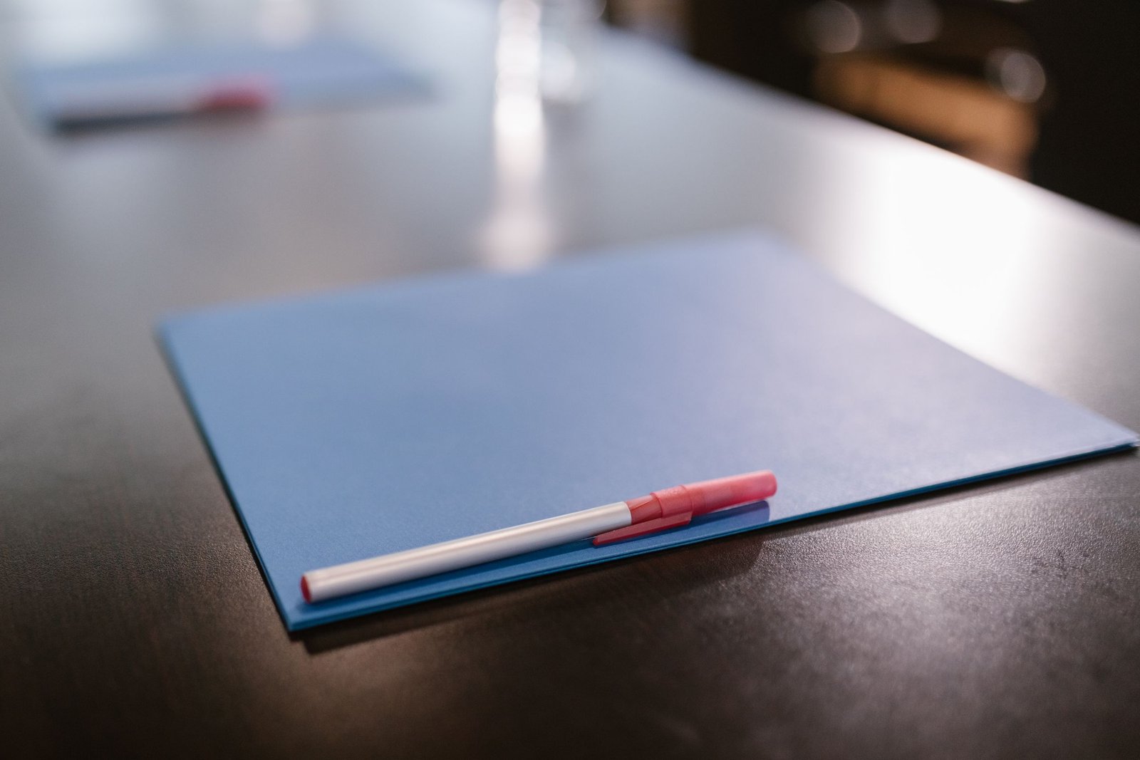 Closed blue document folder and pen on an office table