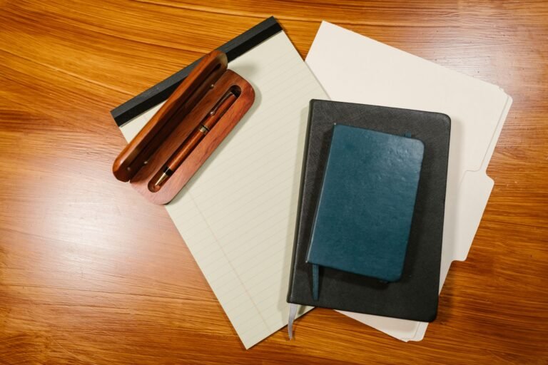 Pen, notebook, and closed document folder arranged on a desk