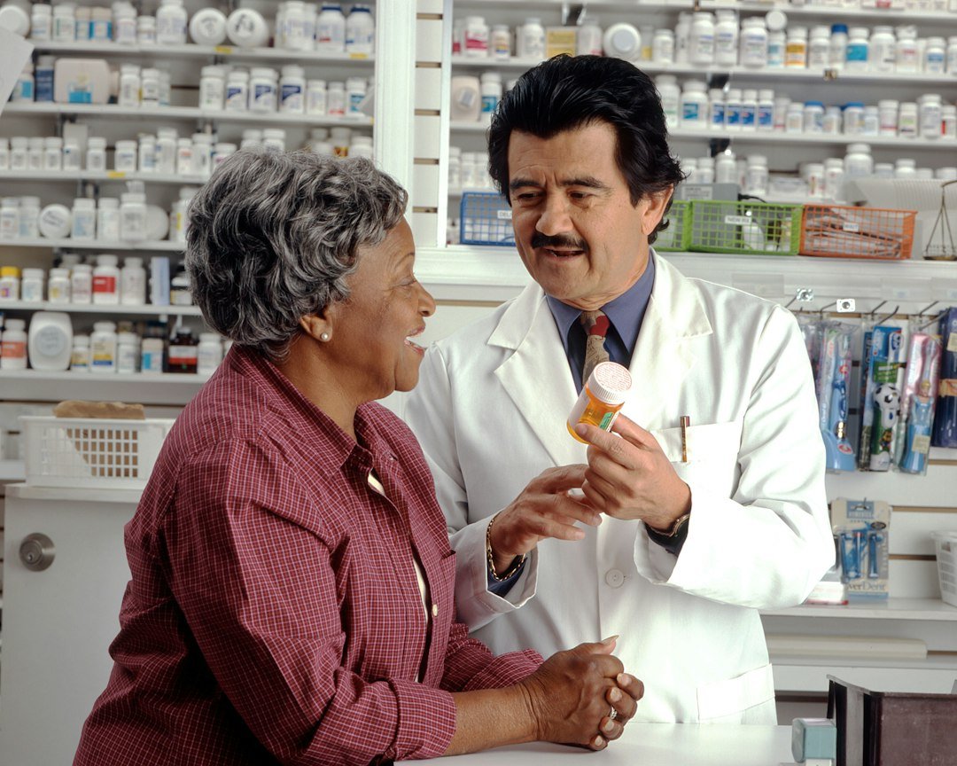 Older woman discussing a prescription with a pharmacist