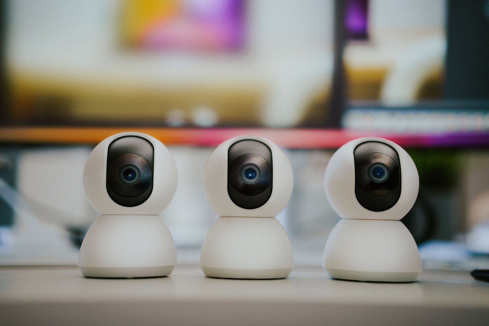 Small home security cameras resting on an indoor table