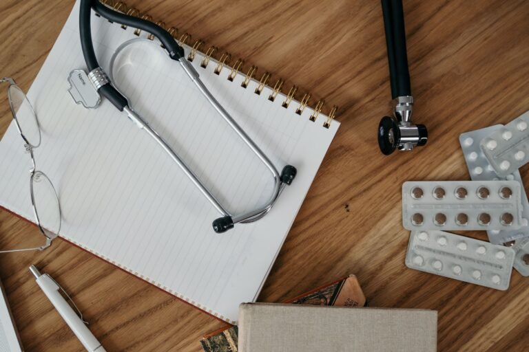 Stethoscope and blank notebook arranged on a healthcare desk