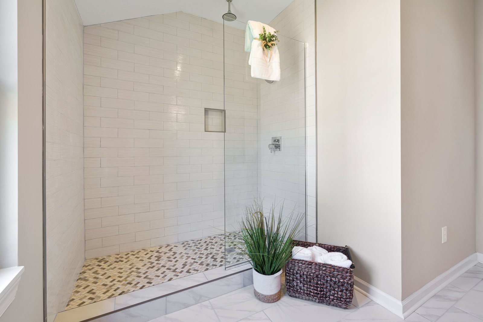 Empty bathroom with glass shower, towels, and clear walking space