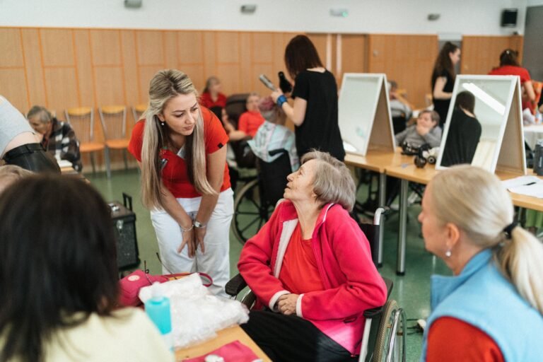 Caregiver speaking with an older woman in a wheelchair at a senior care facility