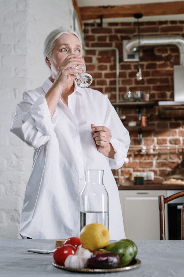 Older woman drinking water at home