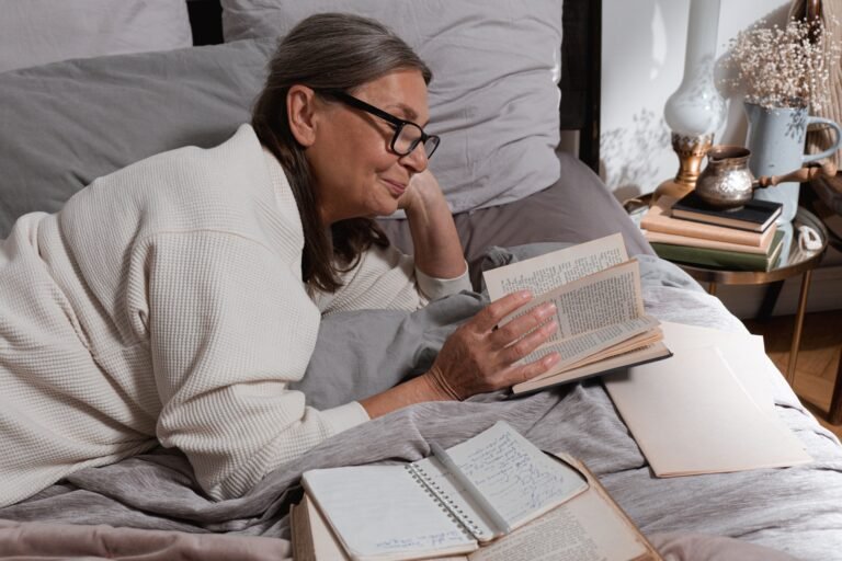 Older woman reading in bed while awake at night