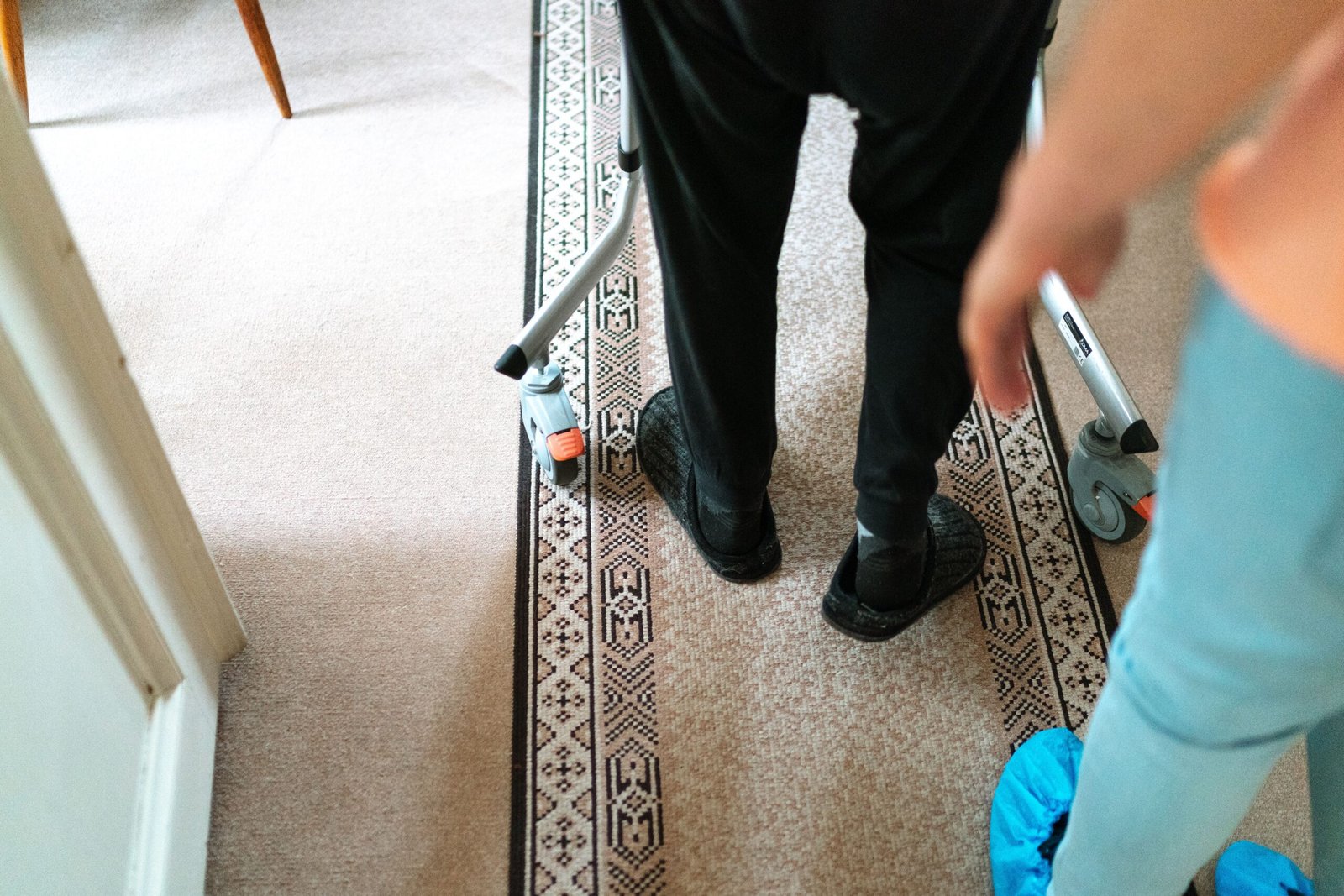 Caregiver assisting an older adult using a walker indoors