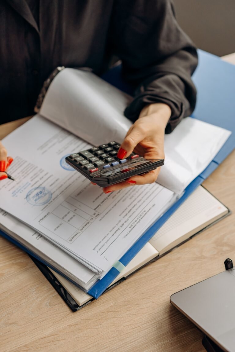 Calculator and financial papers arranged for household recordkeeping.