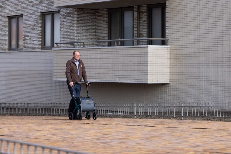 Older man using a rollator while walking outdoors