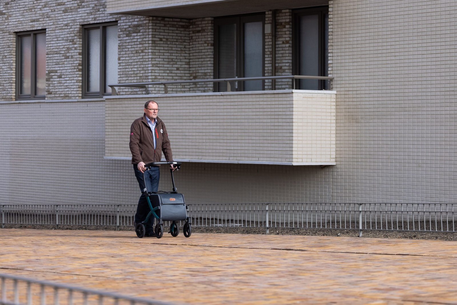 Older man using a rollator while walking outdoors