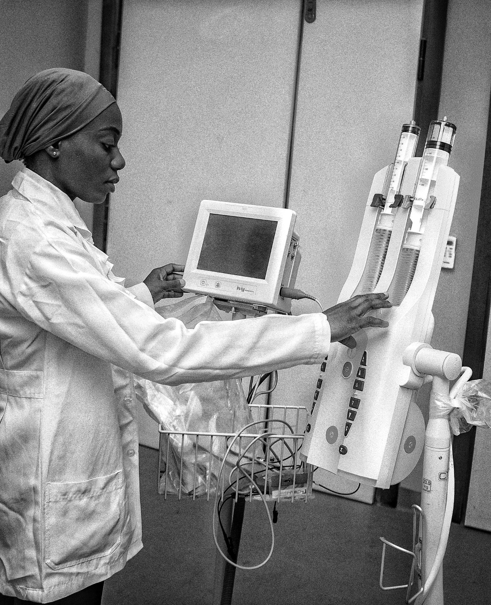 Healthcare professional operating dialysis equipment in a clinical setting