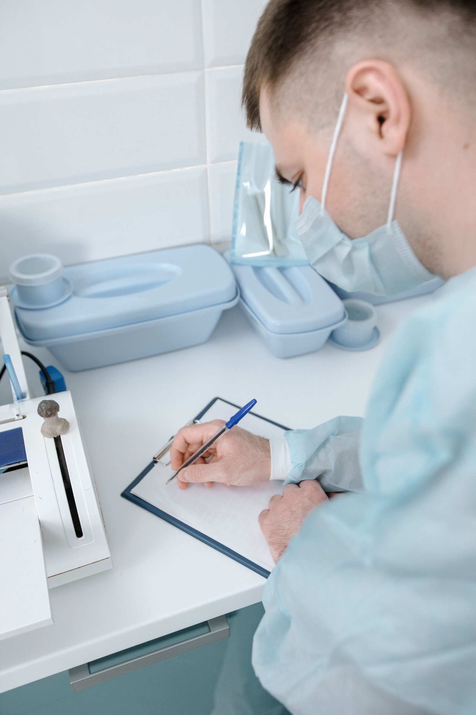Healthcare professional writing notes on a clipboard.