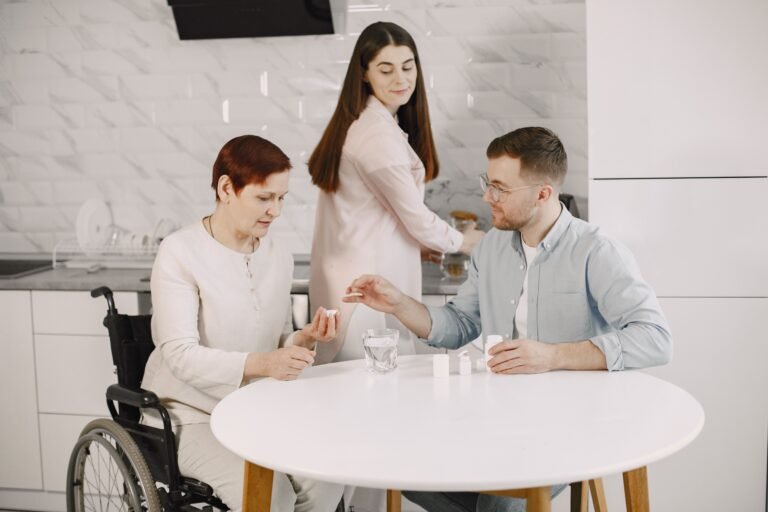 Family helping an older woman seated in a wheelchair at home