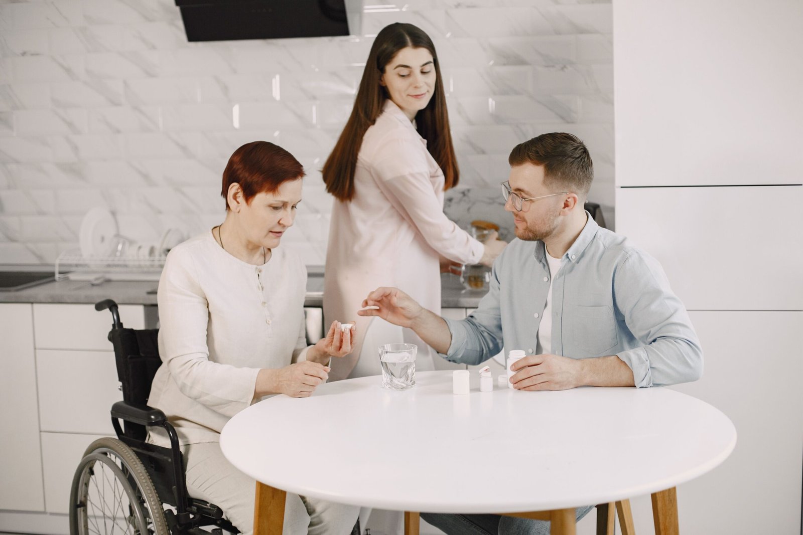 Family helping an older woman seated in a wheelchair at home