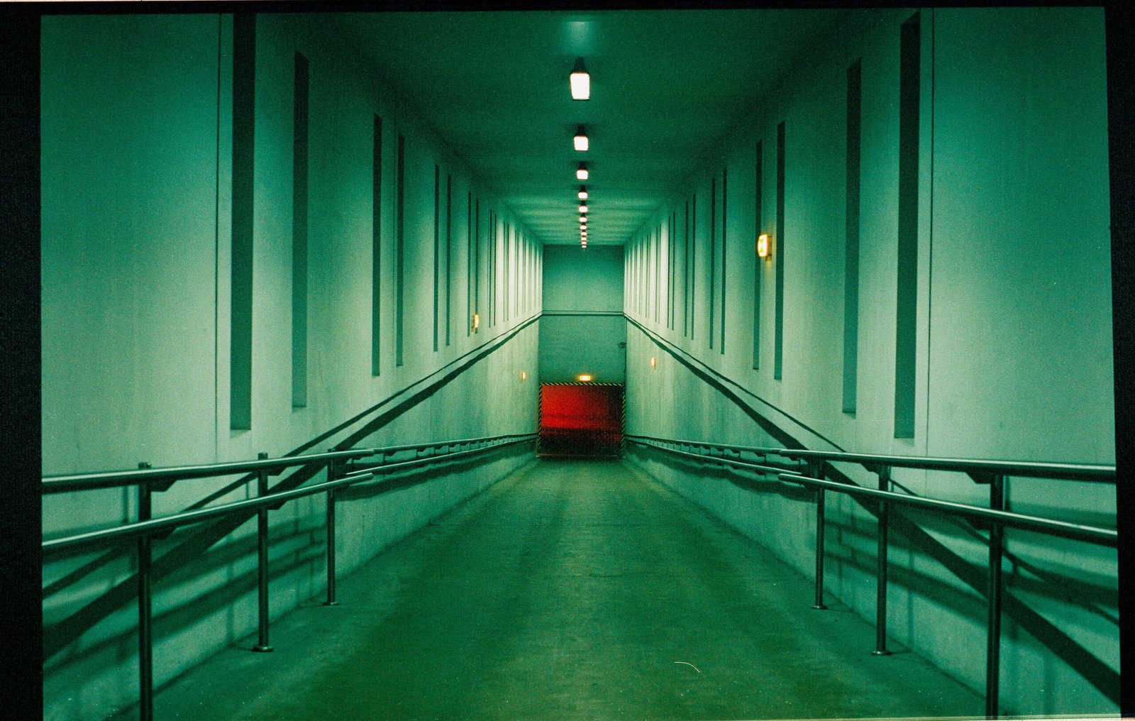 Empty indoor accessibility ramp with metal railings.