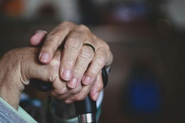 Older adult hand resting on a cane during mobility recovery