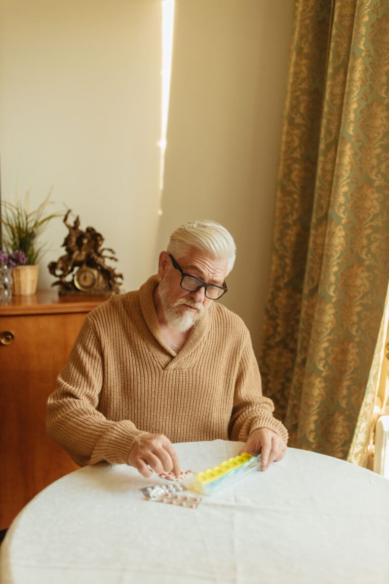 Older adult organizing medications in a pill organizer.