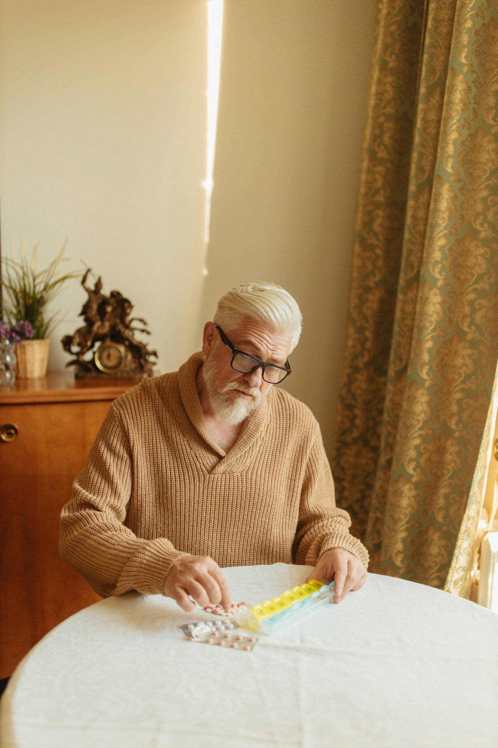 Older adult organizing medications in a pill organizer.