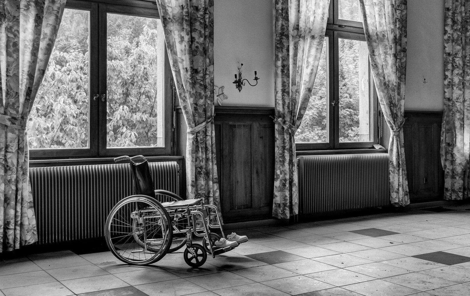 Empty wheelchair in a quiet room near large windows