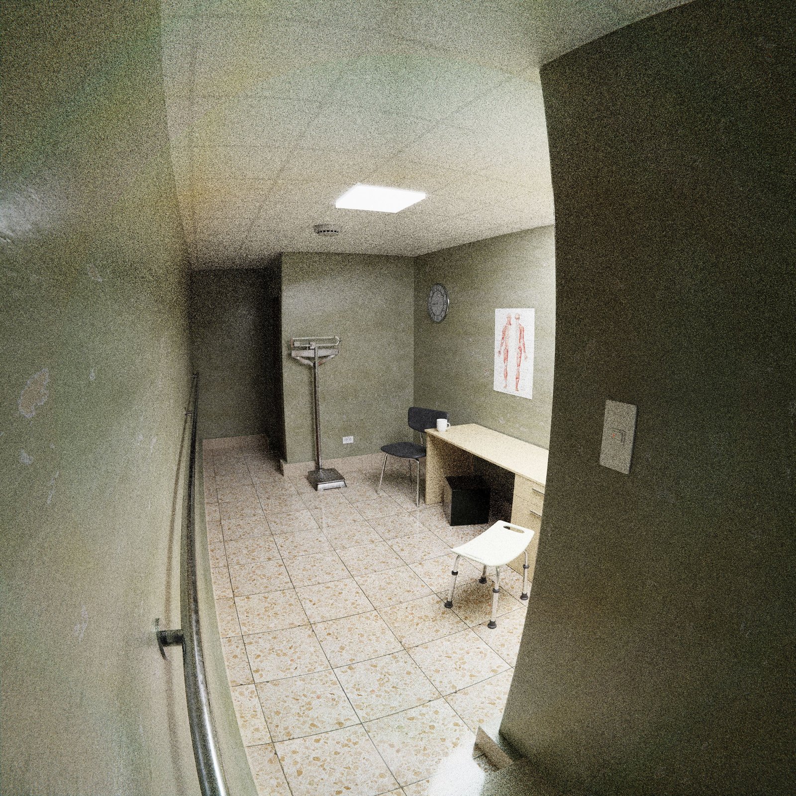 Empty medical office with chairs, desk, and clinical equipment