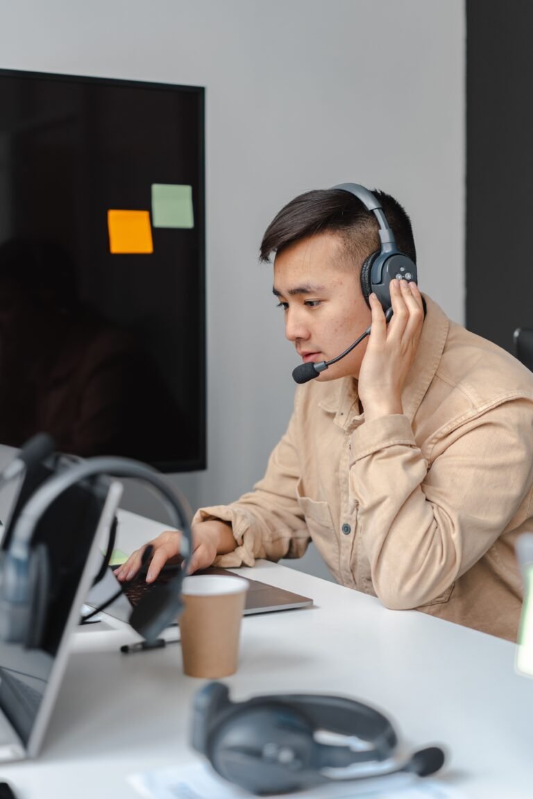 Person wearing a headset while using a laptop for a support call.