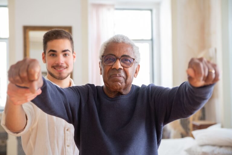 Older man practicing balance exercises with a trainer