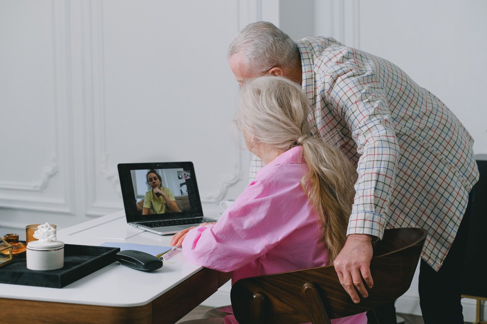Older couple connecting with family through a laptop video call