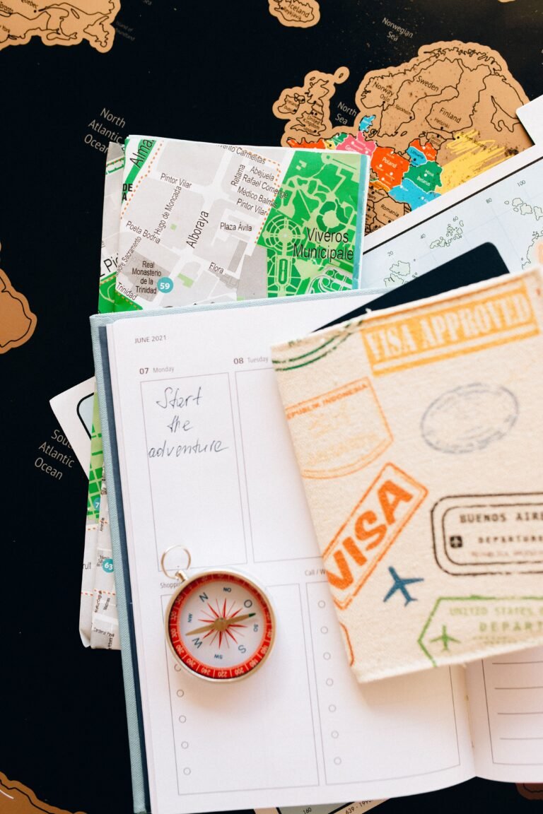 Travel planner, map, compass, and notebook arranged for route planning.