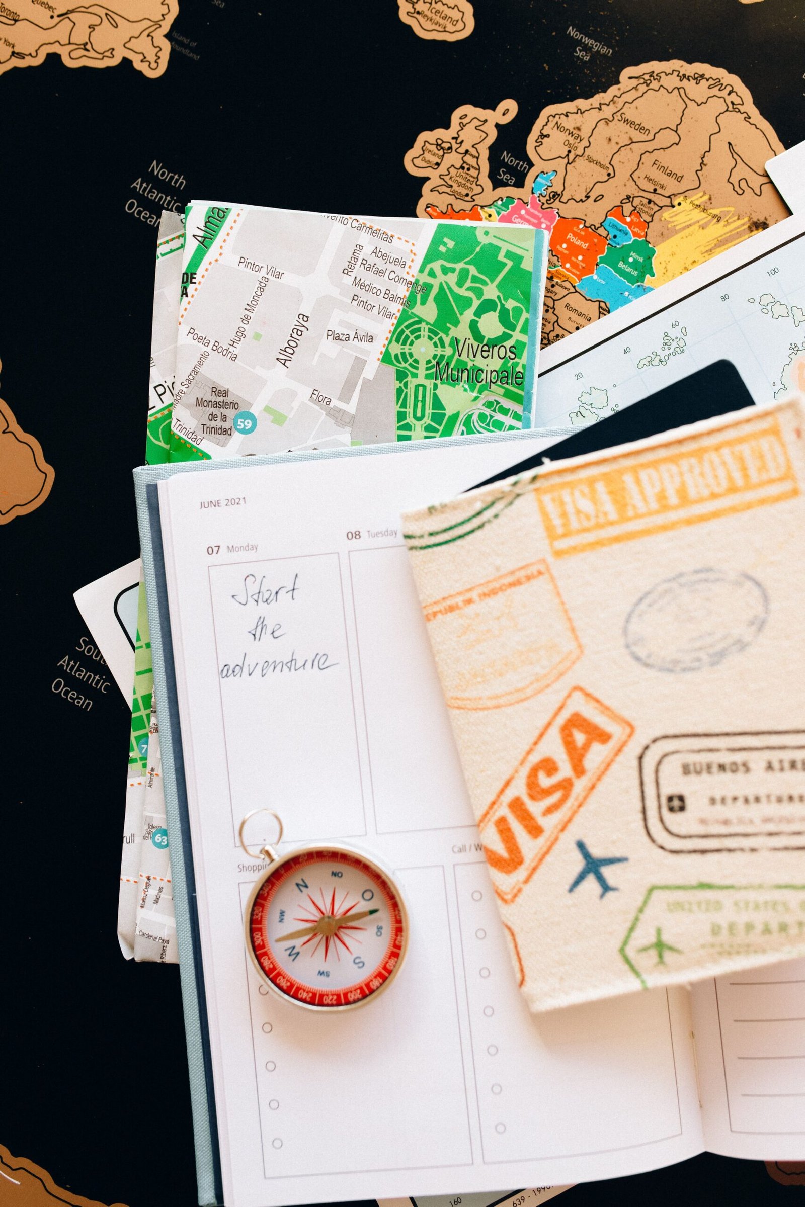 Travel planner, map, compass, and notebook arranged for route planning.