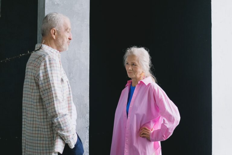 Older couple talking together indoors.