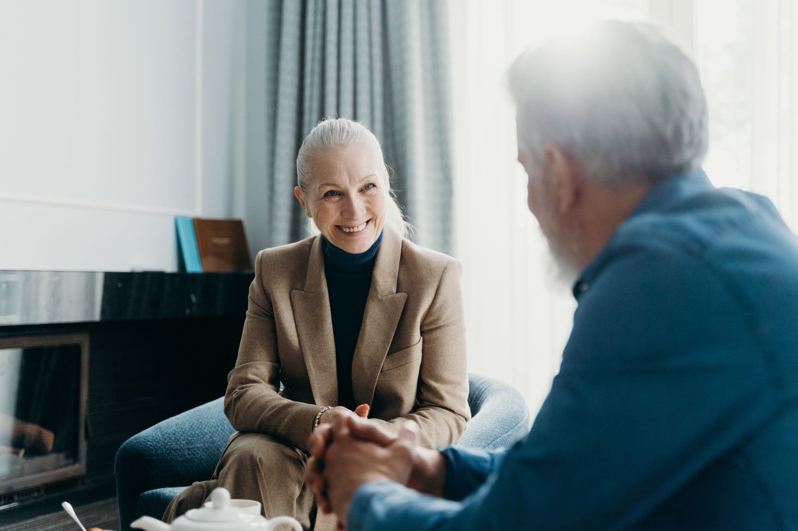 Older adults talking together in a relaxed living-room setting.
